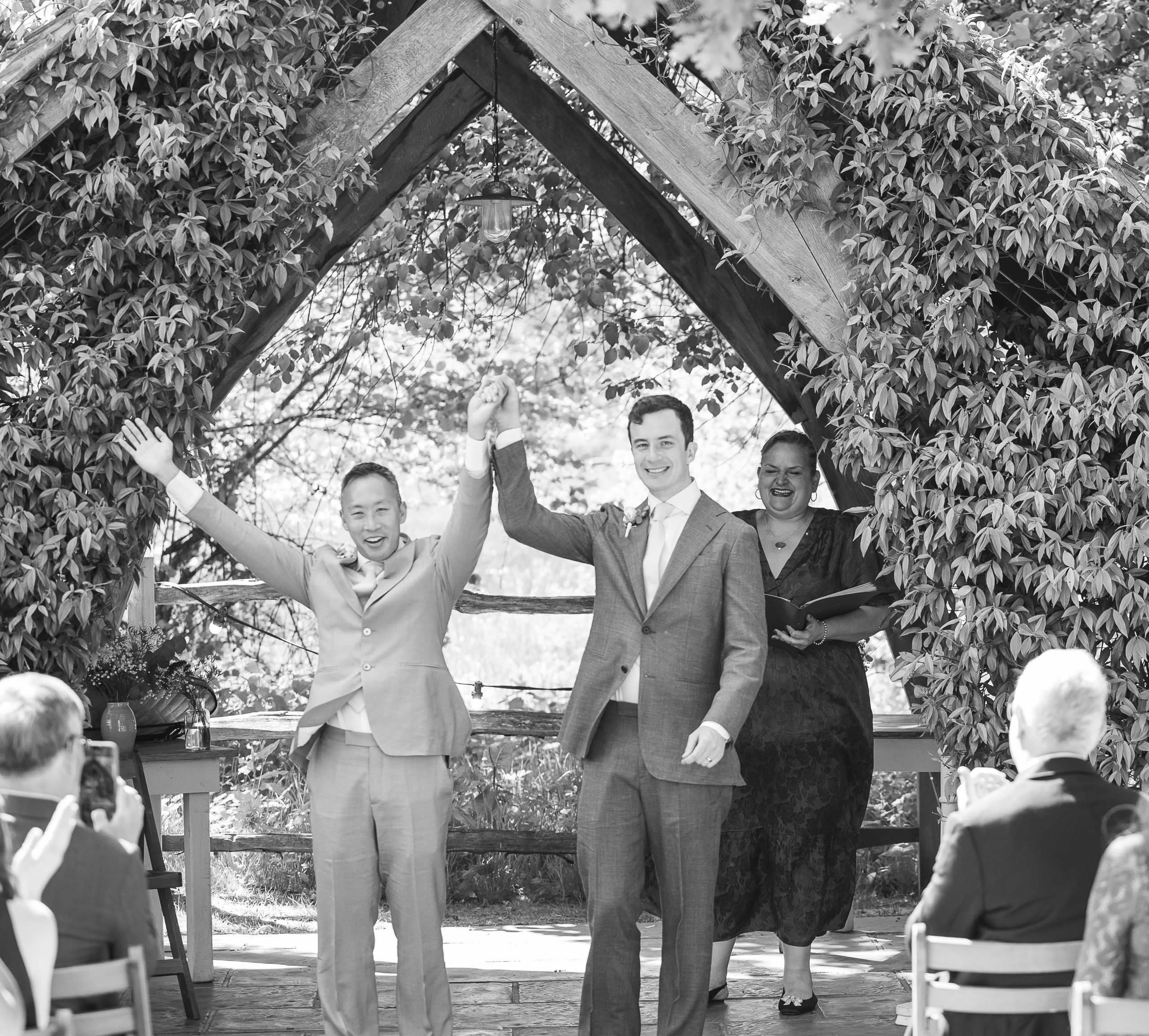 a newly married couple holding hands under a arch