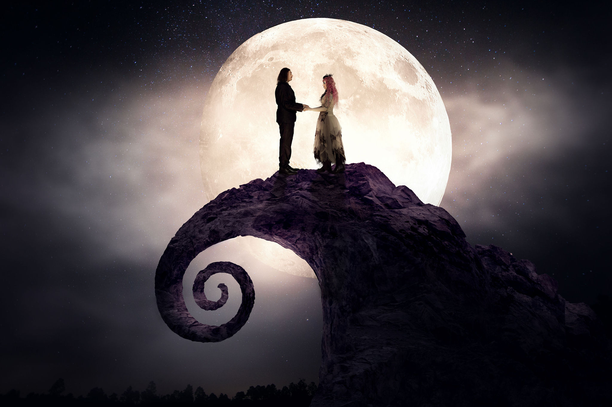 Couple silhouetted against full moon.