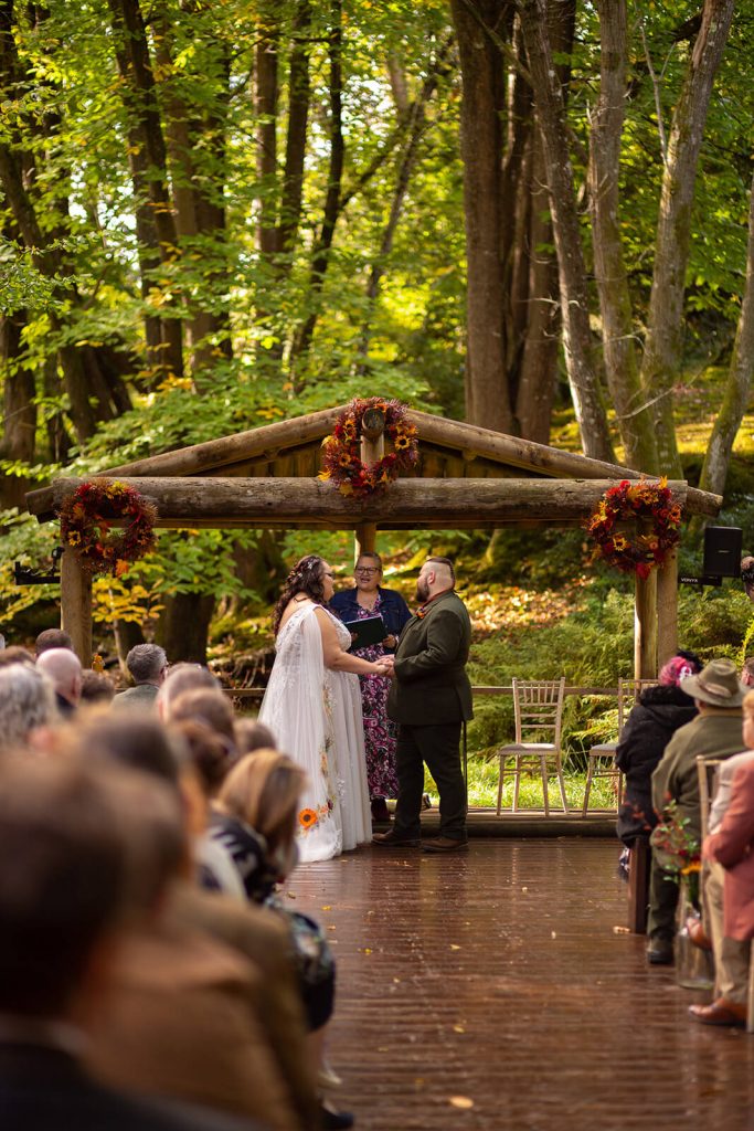 Weddding ceremony in the woods with bride, groom and celebrant. Moonacre Wedding