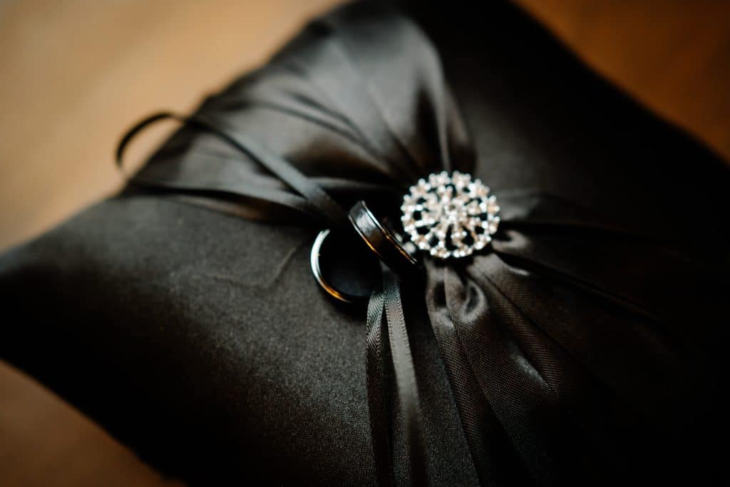 Wedding rings on a black cushion.