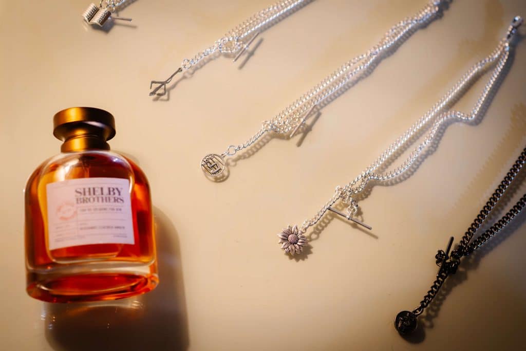 Perfume bottle and silver necklaces.