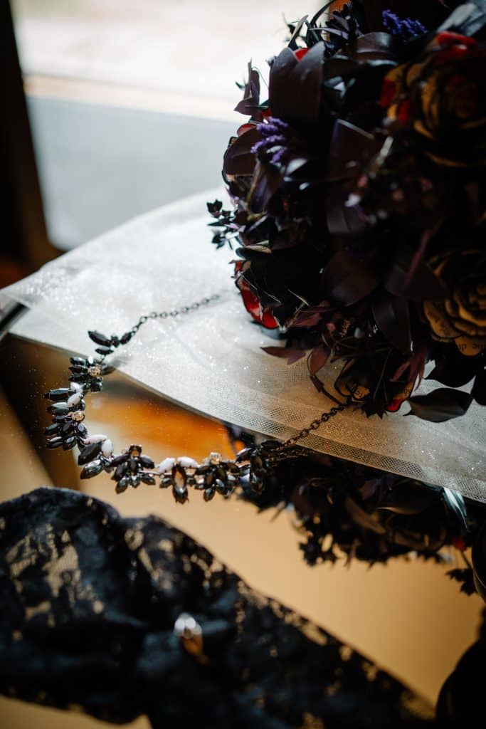 Jewellery and bouquet on reflective surface.