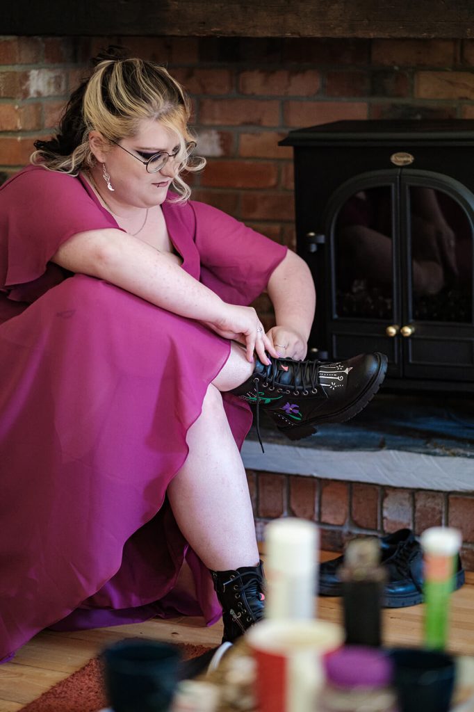 Woman in dress tying boots.