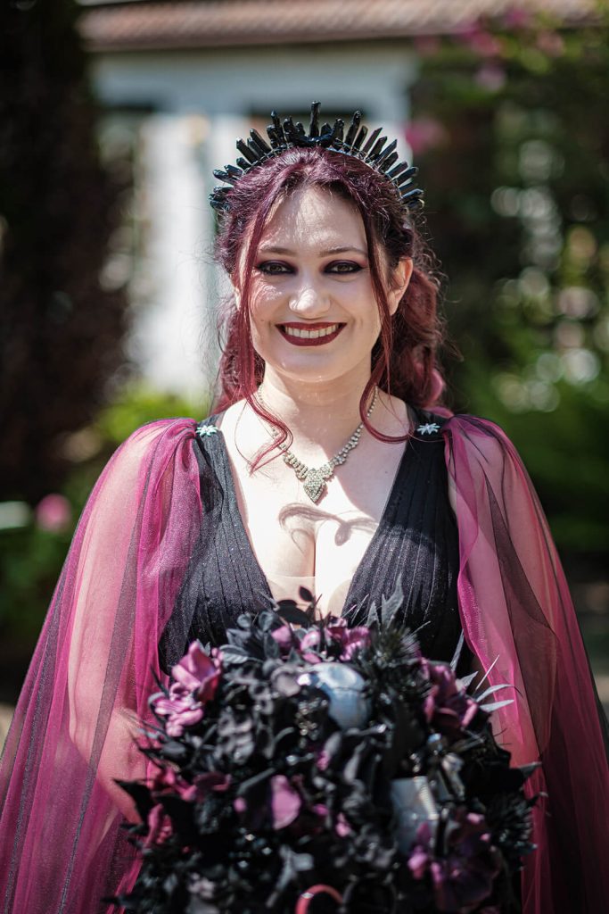Smiling woman in gothic attire.