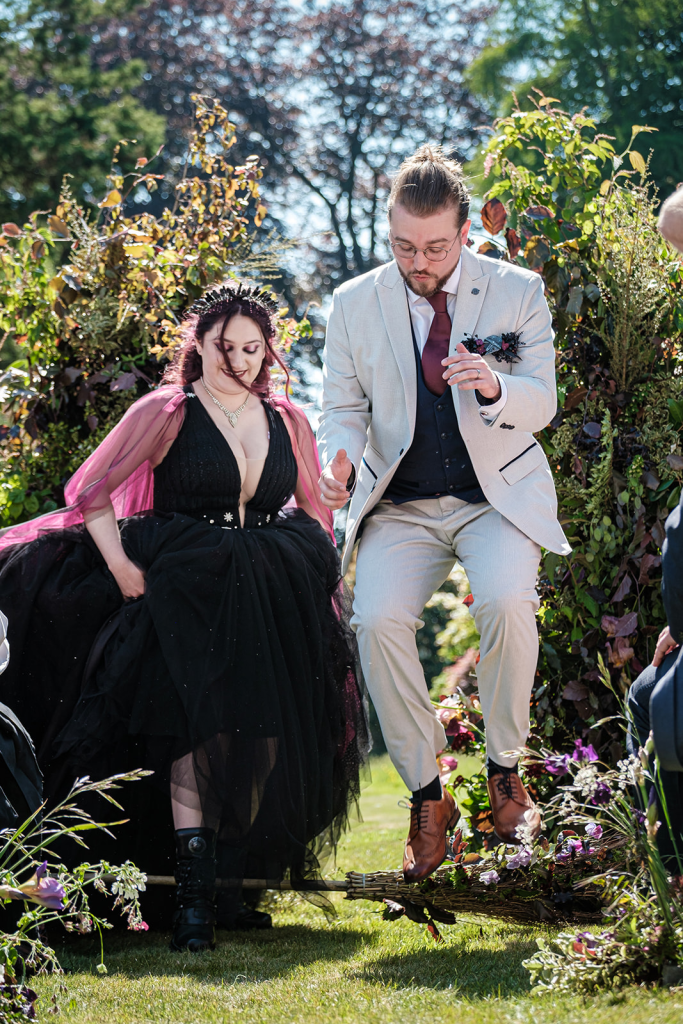 Couple jumping the broom at the end of their Star Wars Wedding