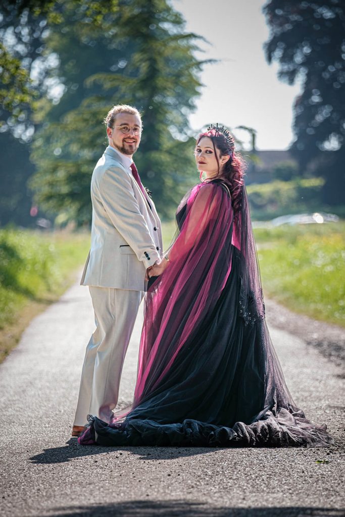 Couple in elegant attire holding hands.