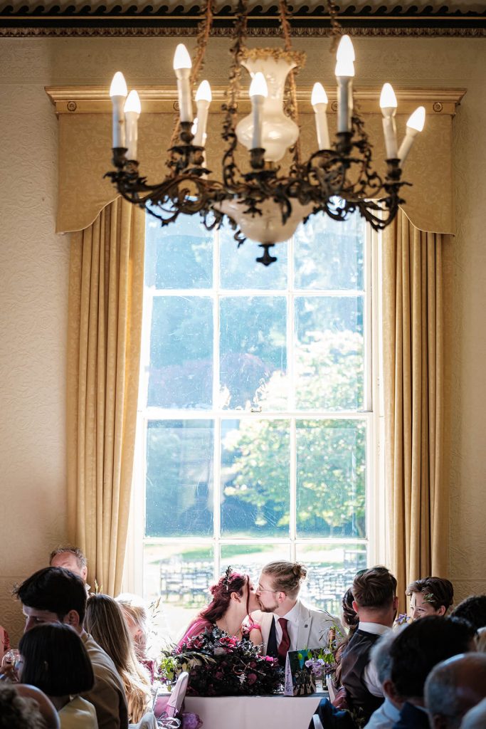 Couple kissing at wedding reception.