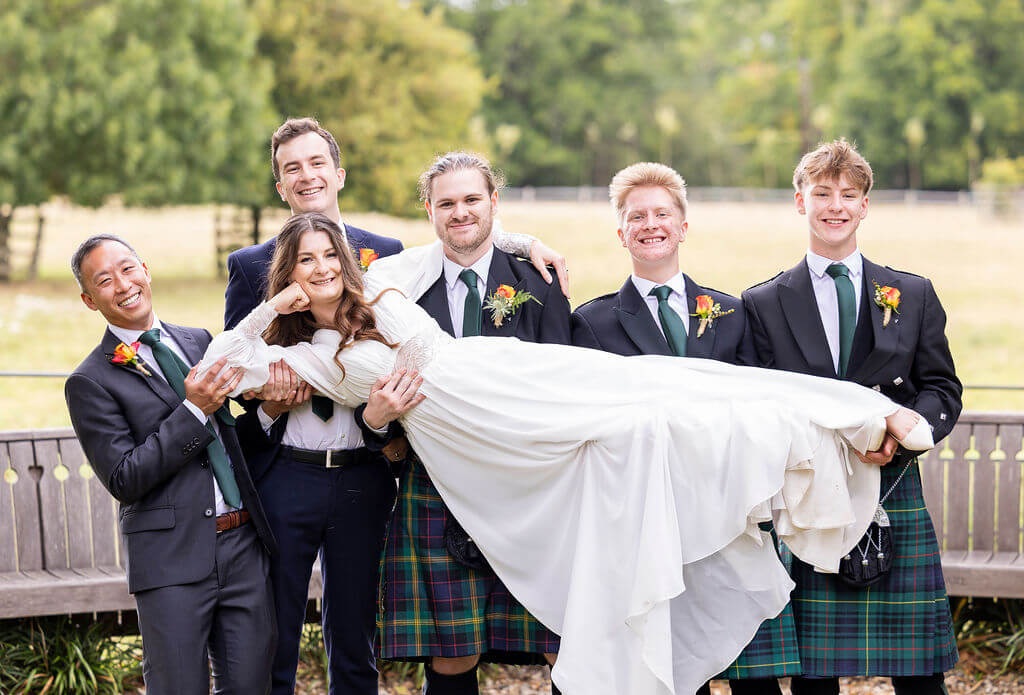 Miranda the Celebrant | Hampshire Ceremonies Bride held by groomsmen in kilts at Gatestreet Barn