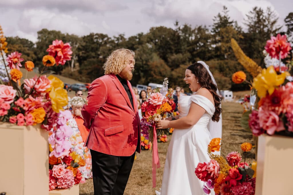 Couple exchanging vows amidst floral decorations.