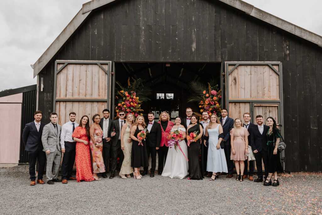 Wedding party outside a barn venue.
