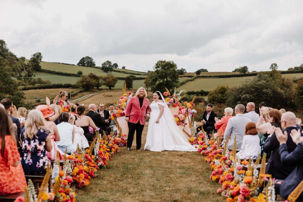 Outdoor wedding with vibrant floral decorations.