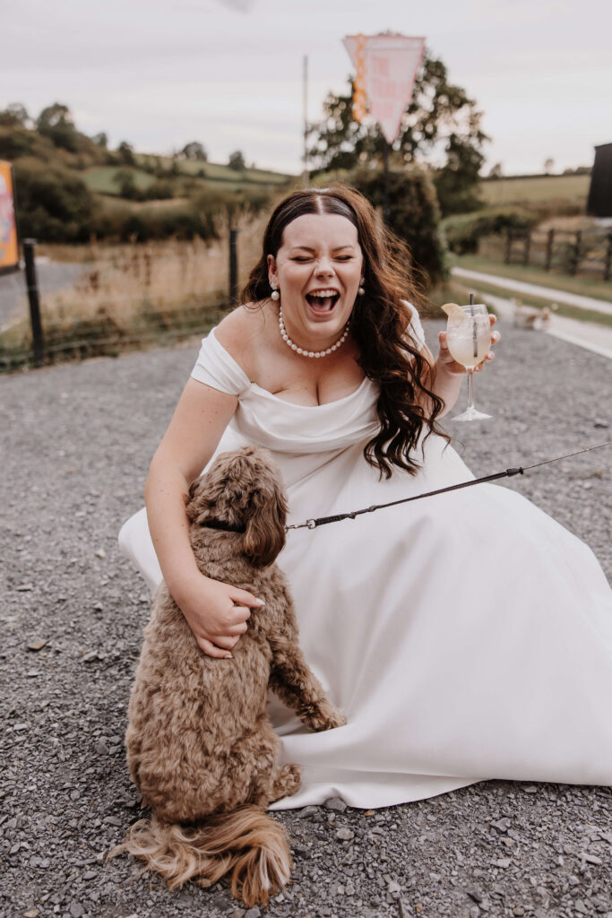 Bride joyfully interacting with dog.