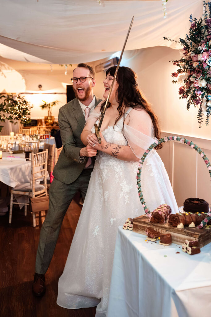 Miranda the Celebrant | Hampshire Ceremonies Couple joyfully cutting wedding cake.