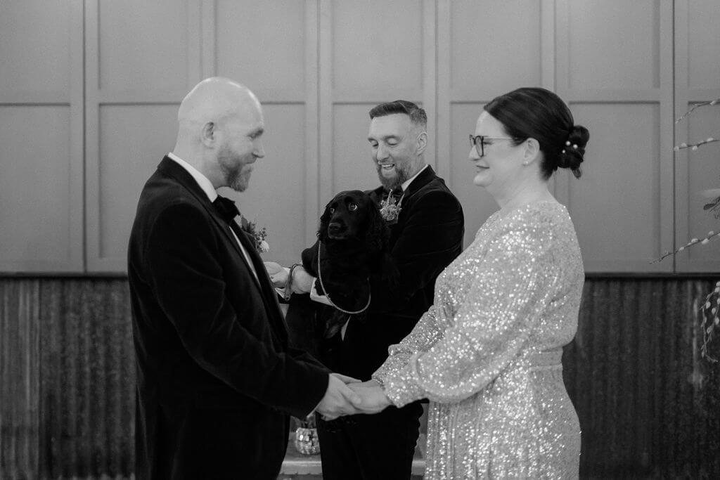 Couple exchanging vows with dog present.